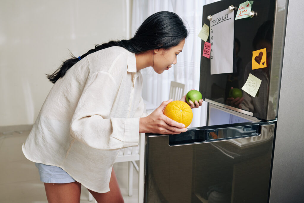young asian woman loungewear taking fruits out refrigerator have some snacks make smoothie